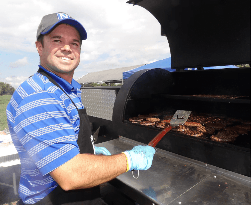 man grilling while smiling at the camera